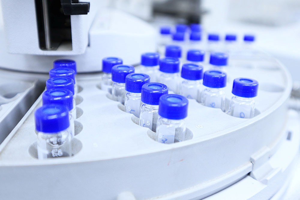 Set of vials with blue caps in lab rack